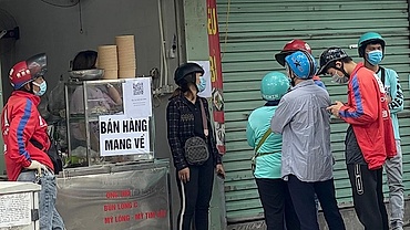 Locals apply pandemic counter measures at eateries in Hanoi