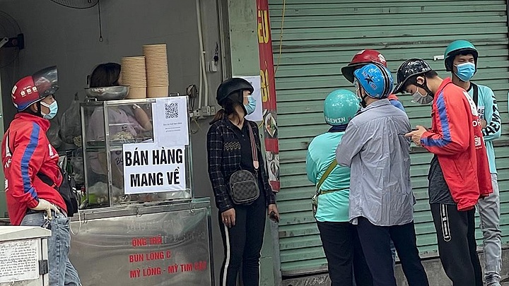 Locals apply pandemic counter measures at eateries in Hanoi